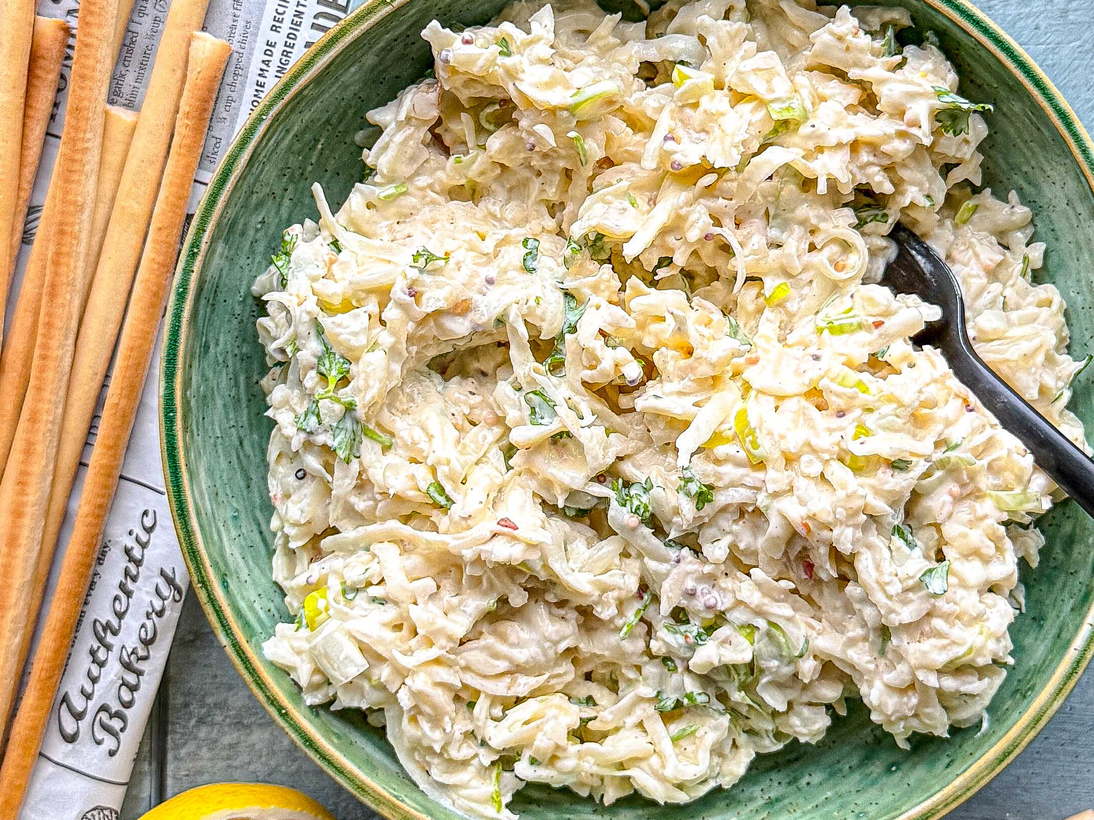 Salát z předvařeného celeru v misce s tyčinkami grissini