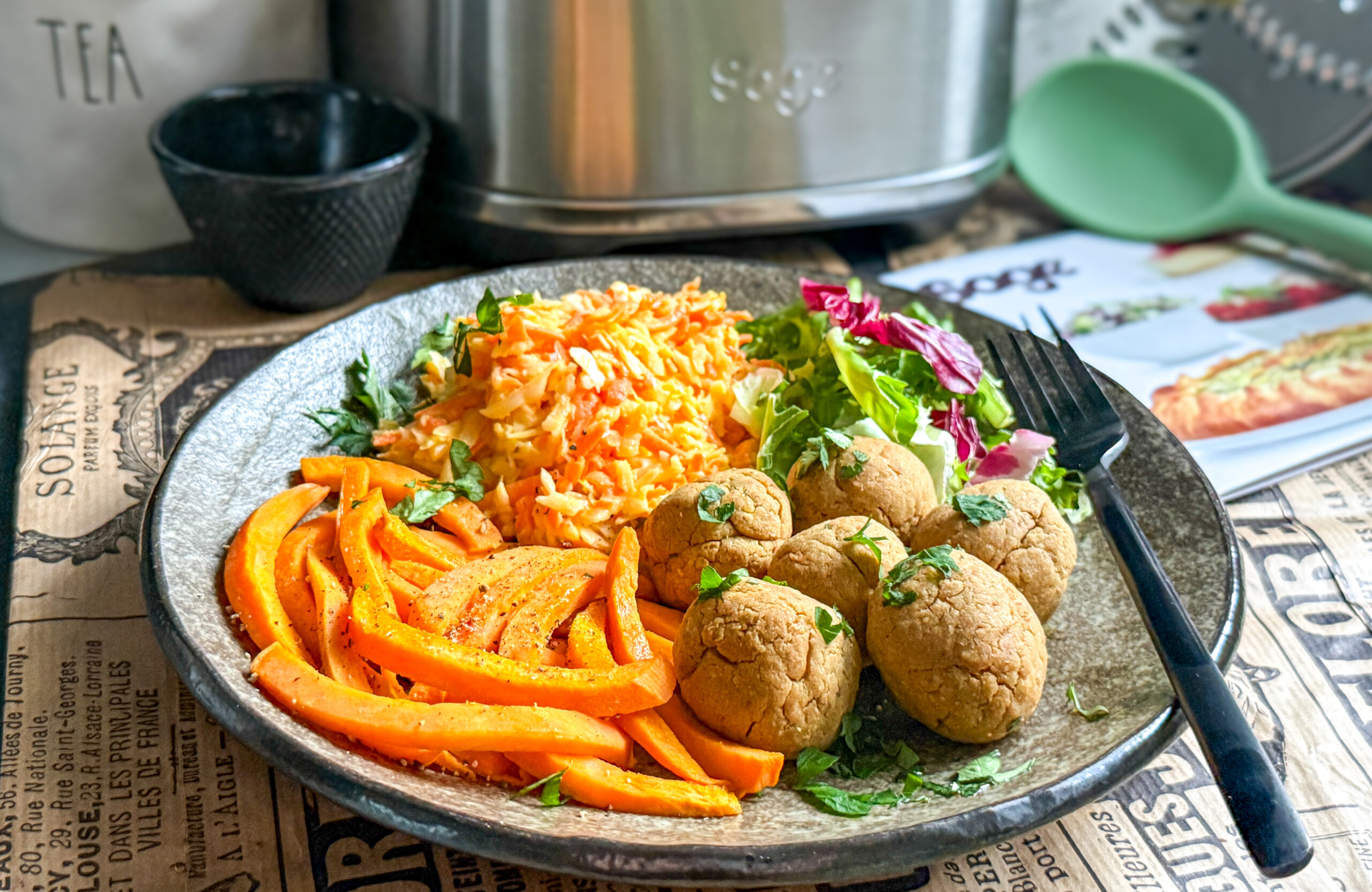 Na talíři jsou cizrnové kuličky, batátové hranolky a coleslaw salát